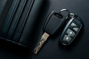 Black leather wallet with car key on a black background