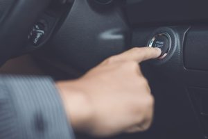 and of man pressing button start/stop car engine inside the modern car.